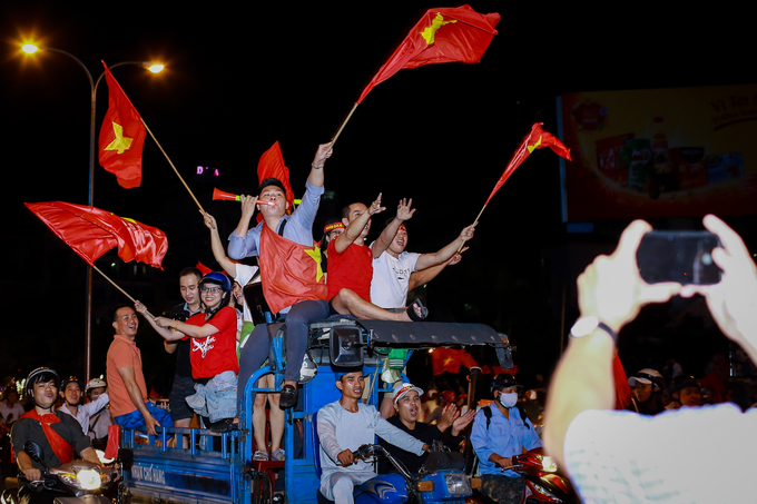 Sau chiến thắng của tuyển U23 Việt Nam trước U23 Qatar, đông đảo người dân TP HCM xuống đường ăn mừng bằng đủ kiểu độc đáo như vẫy cờ trên xe ba gác, gõ xoong chảo, xô nhựa…